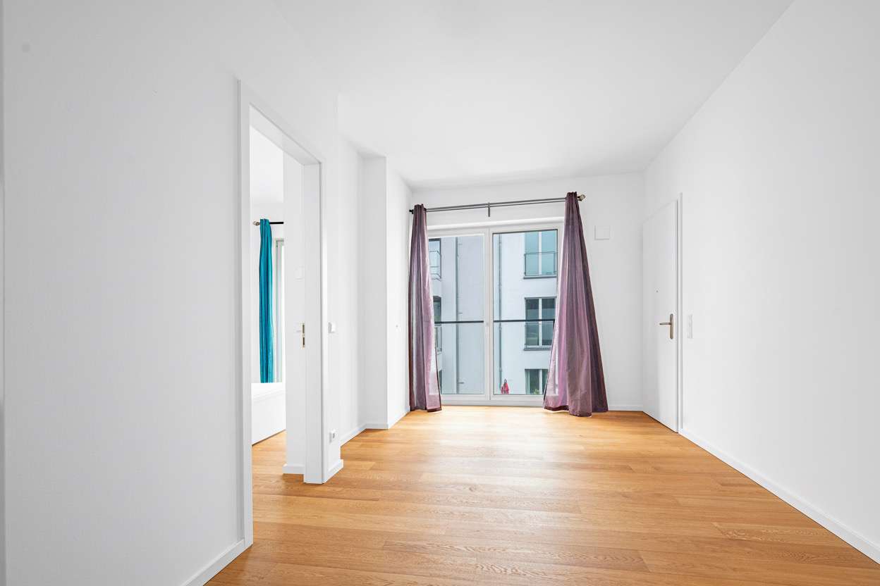 Helles Wohnzimmer mit Zugang zur Dachterrasse u00fcber die rechte Tu00fcr