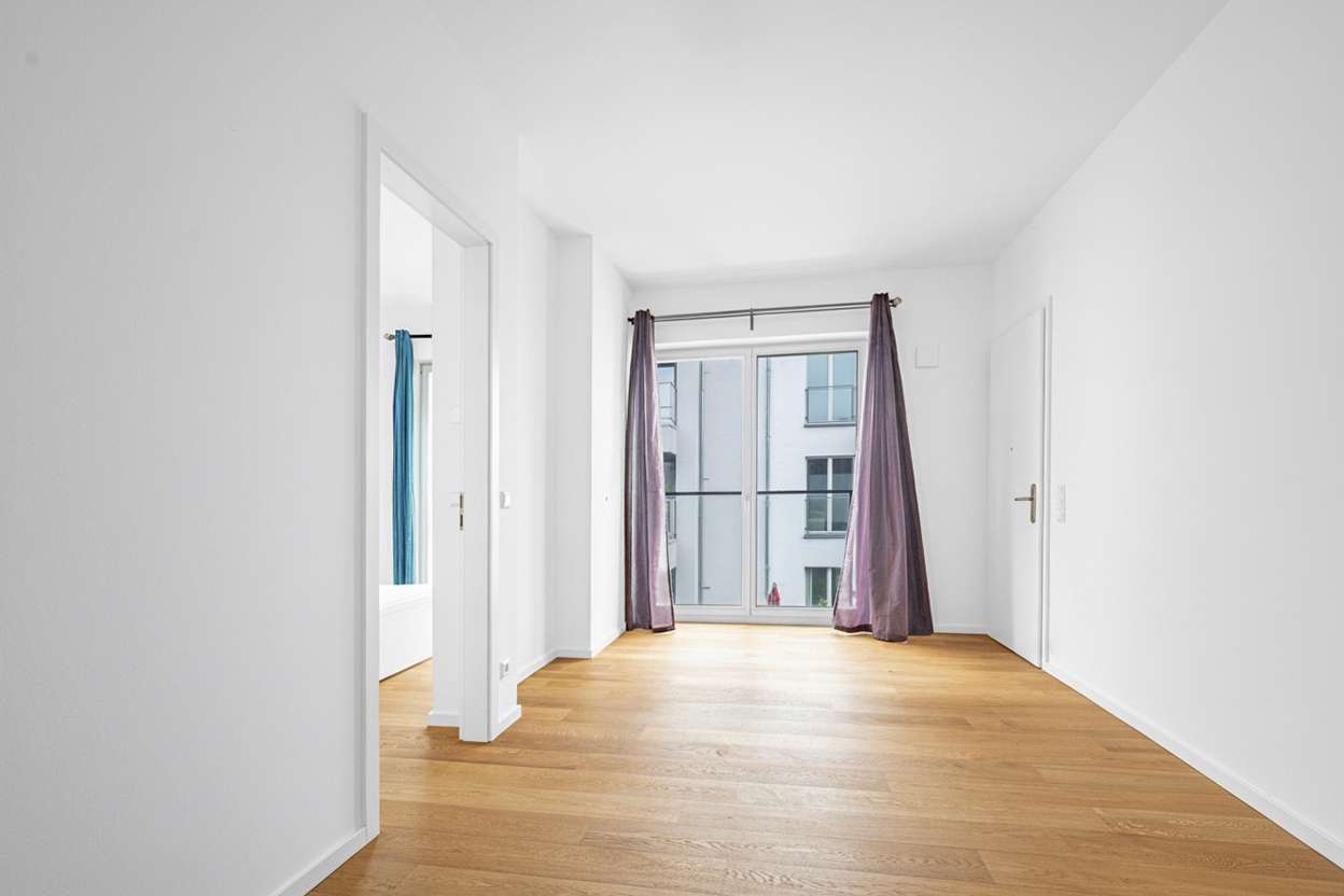 Helles Wohnzimmer mit Zugang zur Dachterrasse u00fcber die rechte Tu00fcr