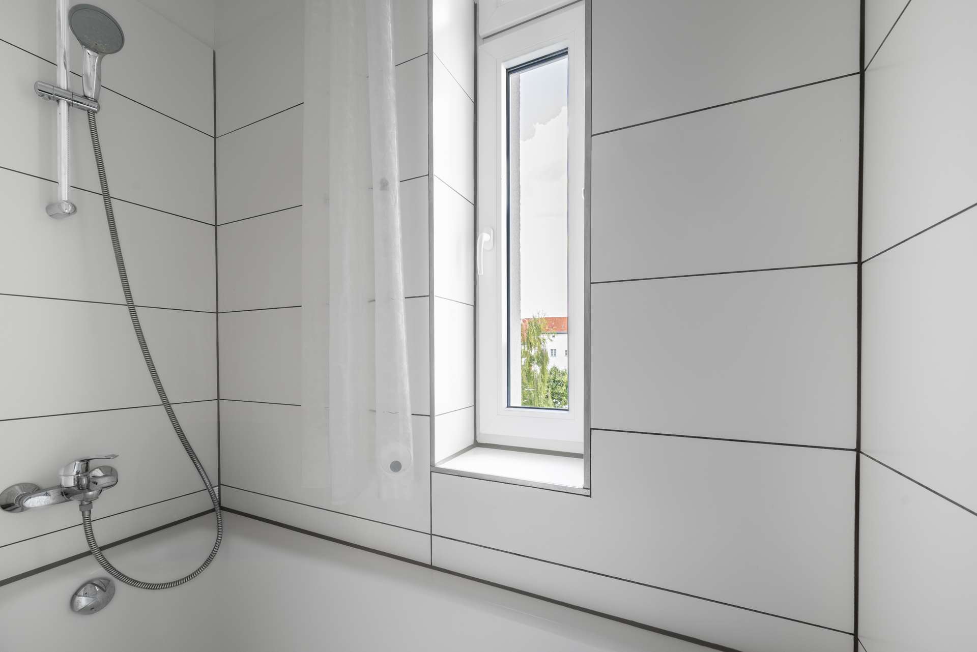 Duschwanne im weiu00df gefliesten Badezimmer