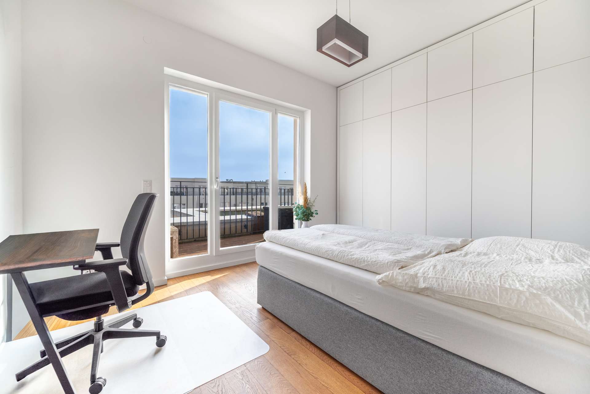 Helles Schlafzimmer mit mau00dfgefertigtem Einbauschrank und Zugang zum Balkon